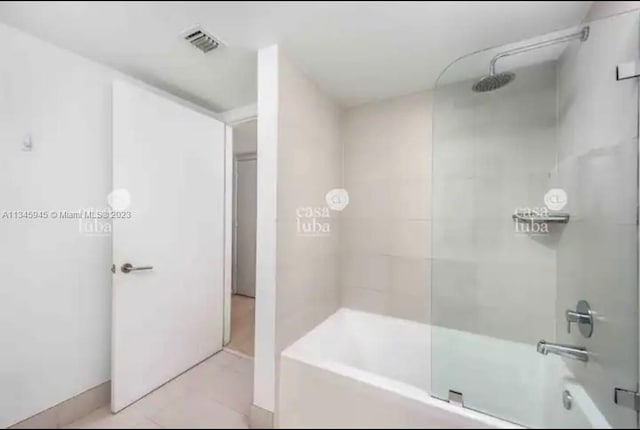 bathroom with tiled shower / bath combo and tile floors