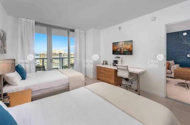 tiled bedroom featuring access to exterior and a wall of windows