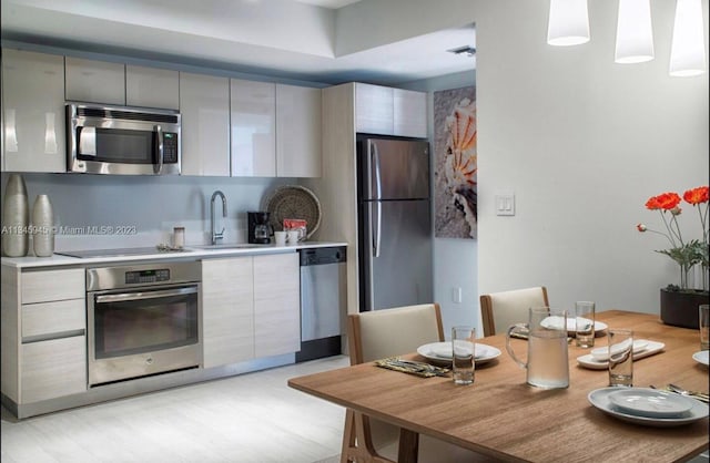 kitchen with sink, appliances with stainless steel finishes, and light wood-type flooring