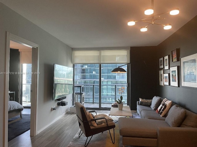 living room featuring expansive windows, wood-type flooring, and an inviting chandelier