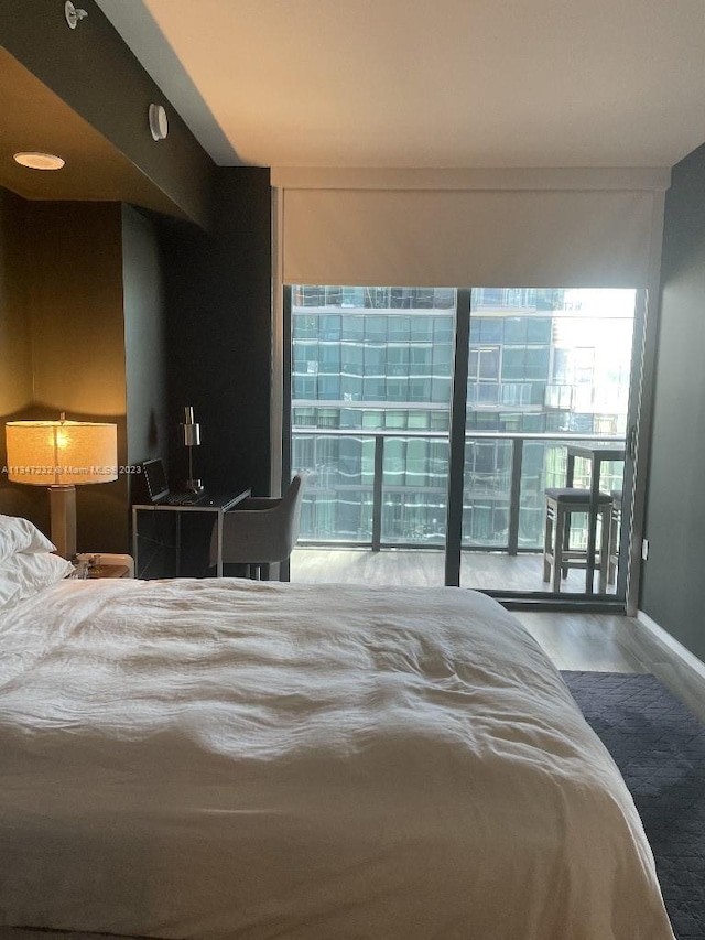 bedroom with a wall of windows and wood-type flooring