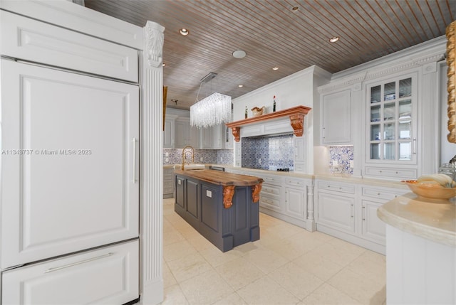 kitchen featuring wood counters, a kitchen island with sink, wood ceiling, and white cabinetry