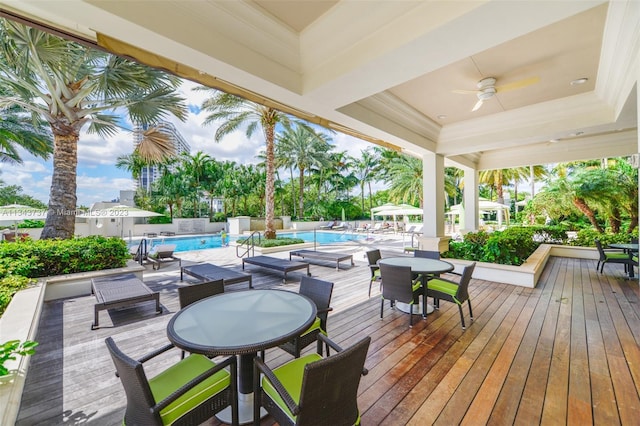 wooden terrace with ceiling fan and a fenced in pool