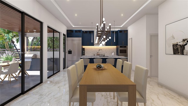 dining room with a raised ceiling, light tile patterned flooring, a chandelier, and sink