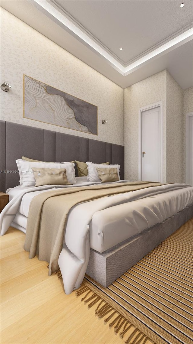 bedroom with a tray ceiling and hardwood / wood-style floors