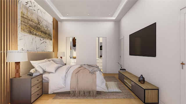 bedroom with light wood-type flooring and a tray ceiling