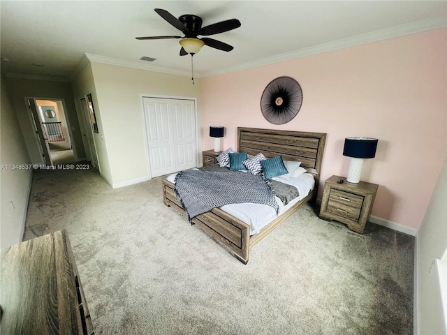 carpeted bedroom featuring crown molding, a closet, and ceiling fan