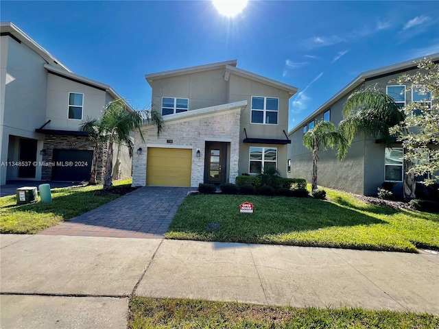 view of front of property featuring a front yard and a garage