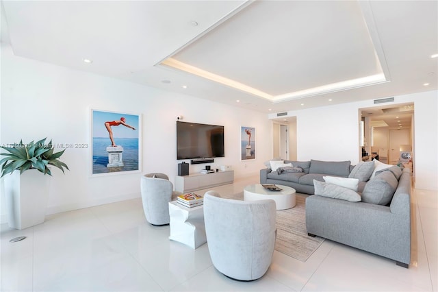 living room with light tile floors and a tray ceiling