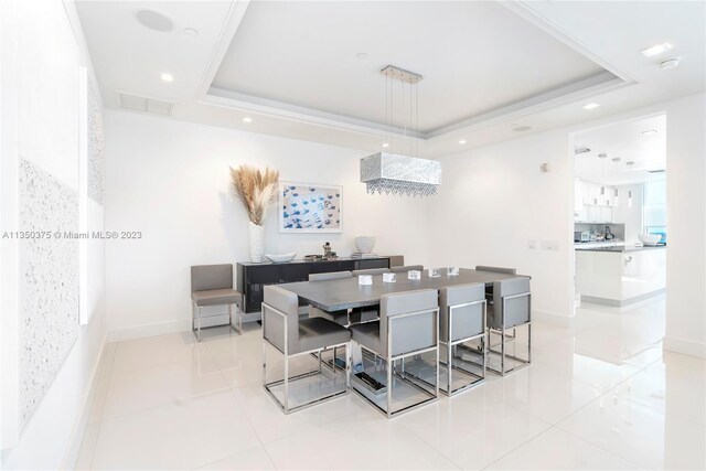 tiled dining room with a tray ceiling