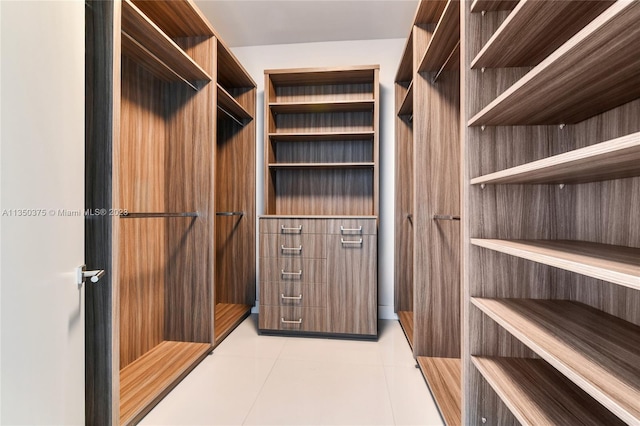 walk in closet with light tile flooring