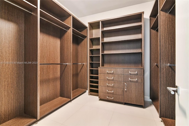 walk in closet featuring light tile floors