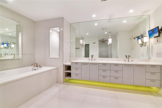 bathroom featuring tile floors, a bathing tub, and vanity