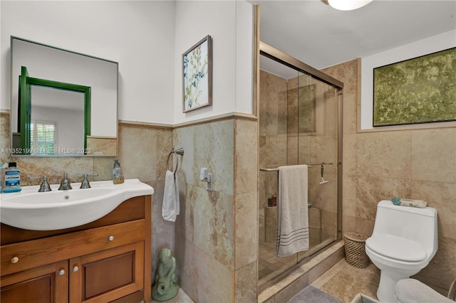 bathroom with tile walls, toilet, vanity, and a shower with door