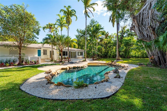 view of pool with a lawn and a patio