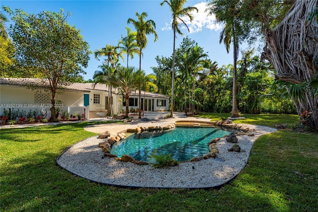 view of swimming pool featuring a lawn and a patio