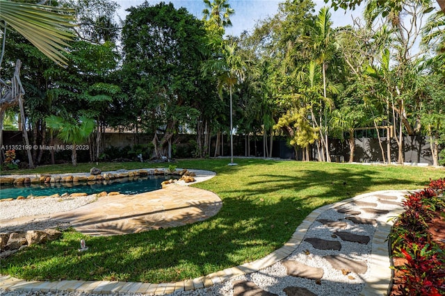 view of swimming pool featuring a yard