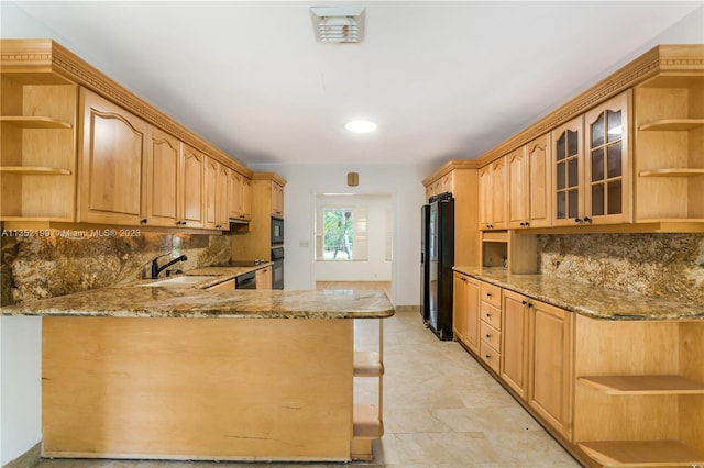 kitchen with backsplash, light stone counters, and black appliances