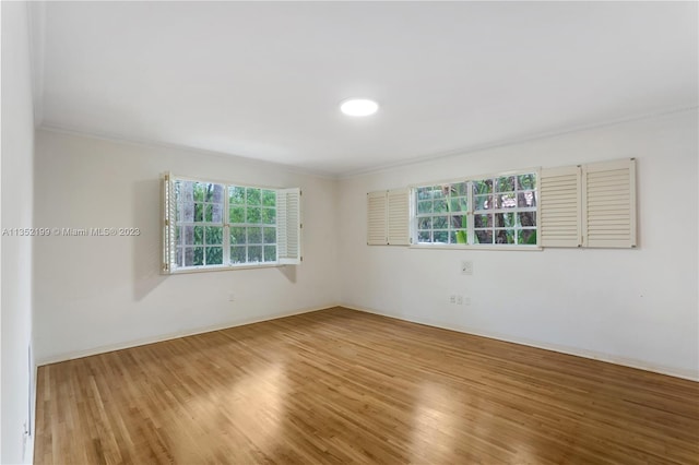 unfurnished room with hardwood / wood-style flooring and crown molding