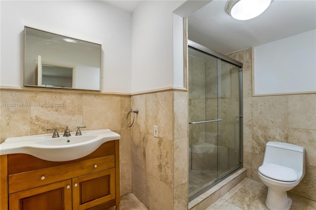 bathroom featuring an enclosed shower, large vanity, toilet, and tile walls