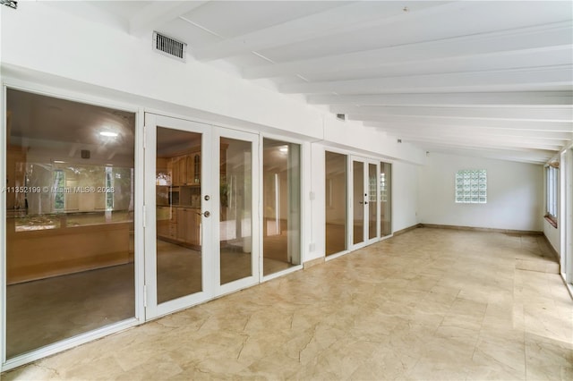 interior space featuring french doors and lofted ceiling with beams