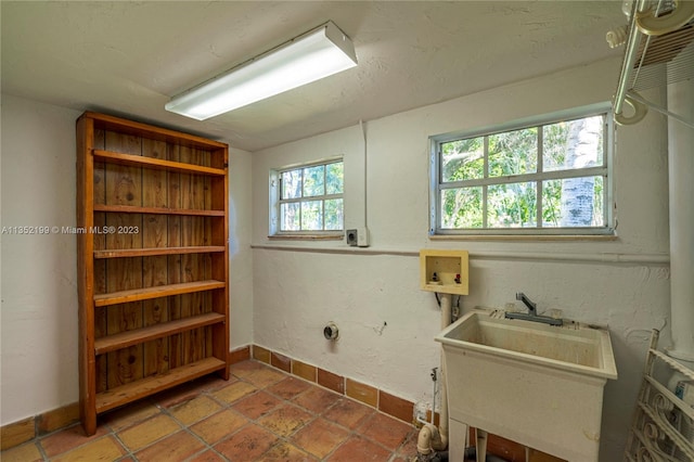 laundry room with tile flooring and sink