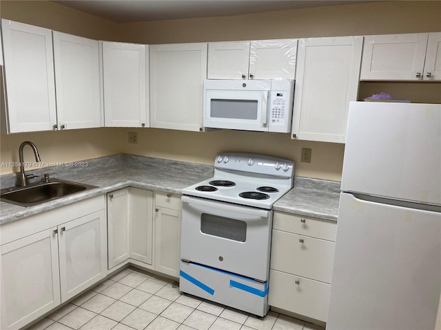 kitchen featuring white appliances, light tile patterned floors, white cabinetry, and sink