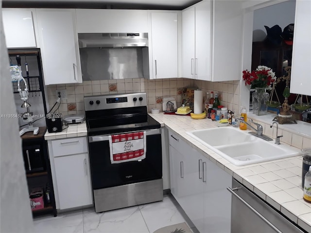 kitchen featuring white cabinetry, backsplash, sink, stainless steel appliances, and wall chimney range hood