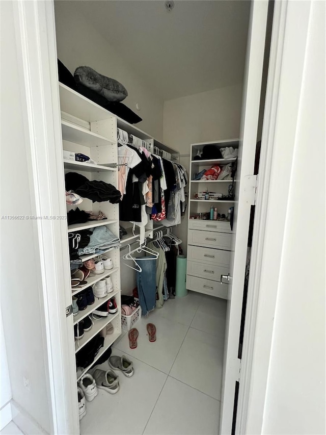 walk in closet featuring light tile floors