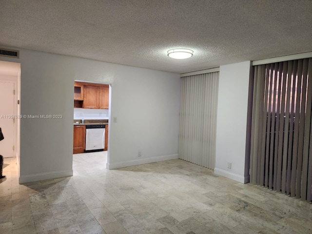 unfurnished room with a textured ceiling