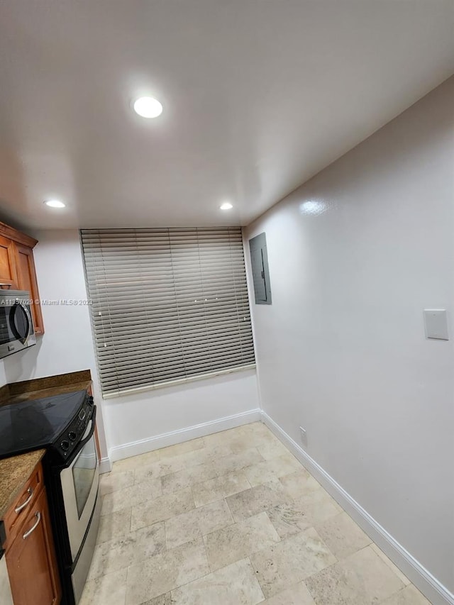 kitchen with stone countertops and black range with electric stovetop