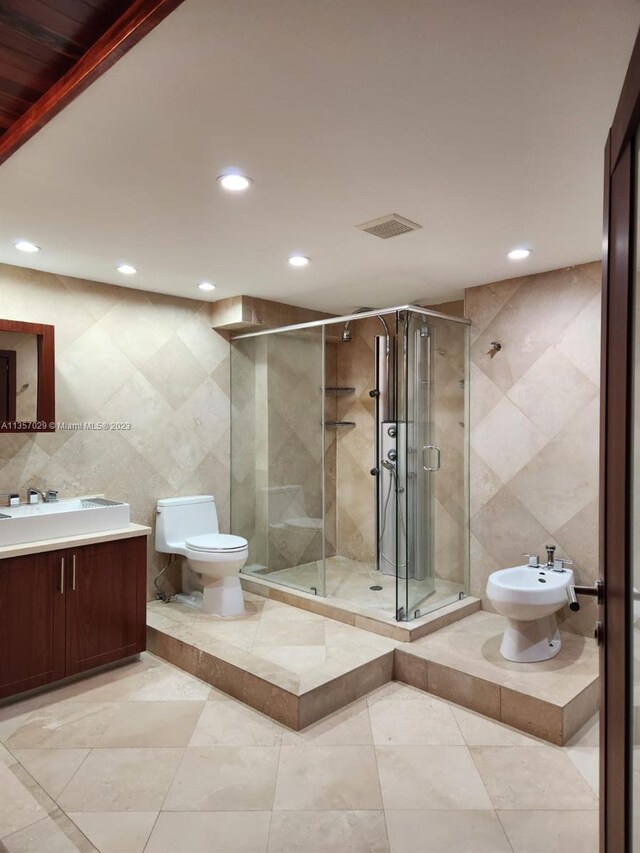 bathroom featuring a bidet, an enclosed shower, toilet, vanity, and tile walls