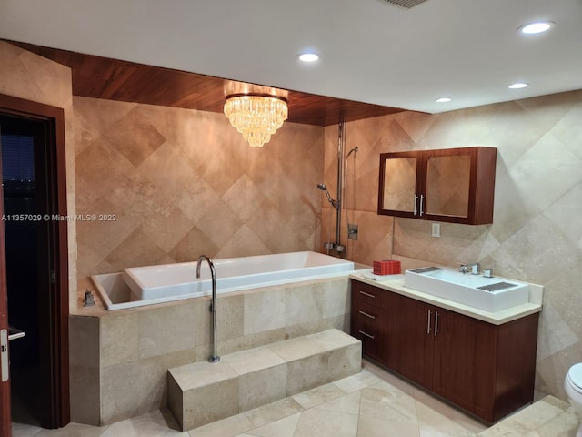 full bathroom with tile patterned floors, vanity, tile walls, and an inviting chandelier