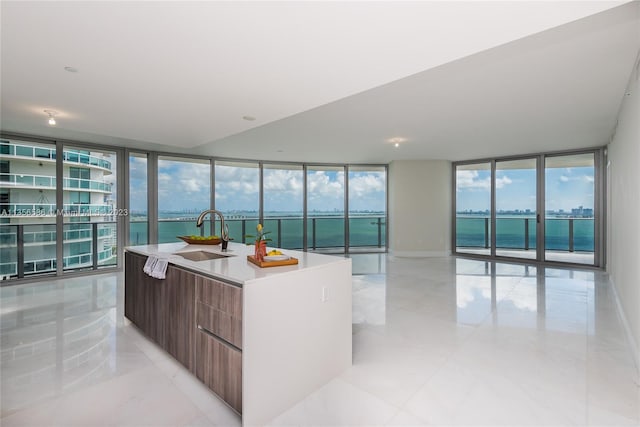 interior space featuring a wall of windows, sink, and a water view