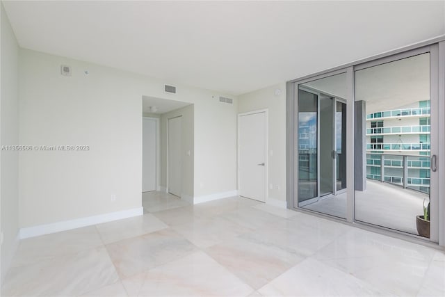 tiled empty room with floor to ceiling windows