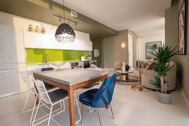 dining room with light tile floors and sink