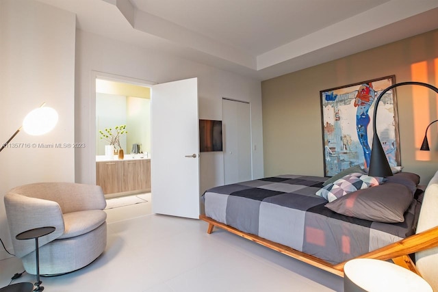 tiled bedroom featuring a closet and a tray ceiling