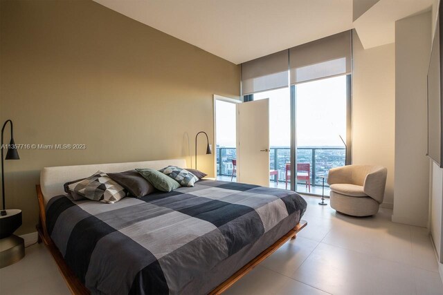 tiled bedroom featuring access to outside and a towering ceiling