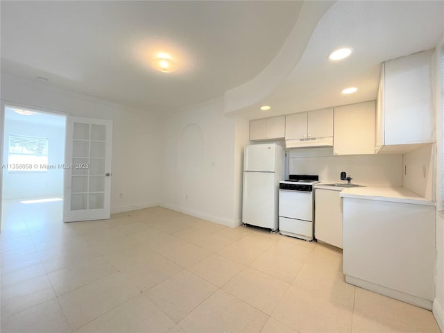 kitchen with light tile floors, white appliances, and white cabinetry