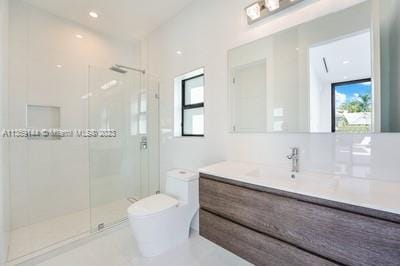 bathroom with vanity, a shower with shower door, and toilet