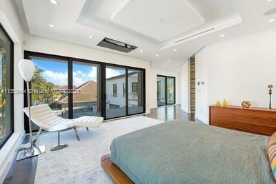 bedroom with a tray ceiling and access to exterior