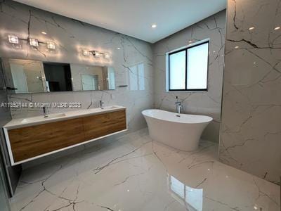 bathroom with a bathing tub, vanity, and tile walls