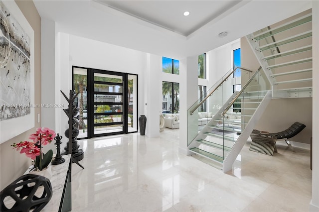 entrance foyer with a raised ceiling and a towering ceiling