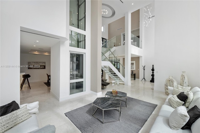 living room featuring a towering ceiling and a notable chandelier