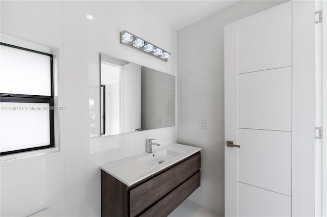 bathroom with vanity and tile walls