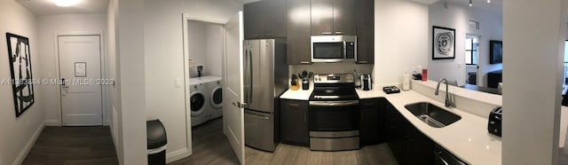 bathroom with washing machine and dryer, hardwood / wood-style floors, and sink