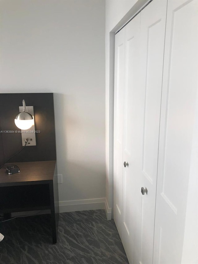 hallway with dark tile flooring