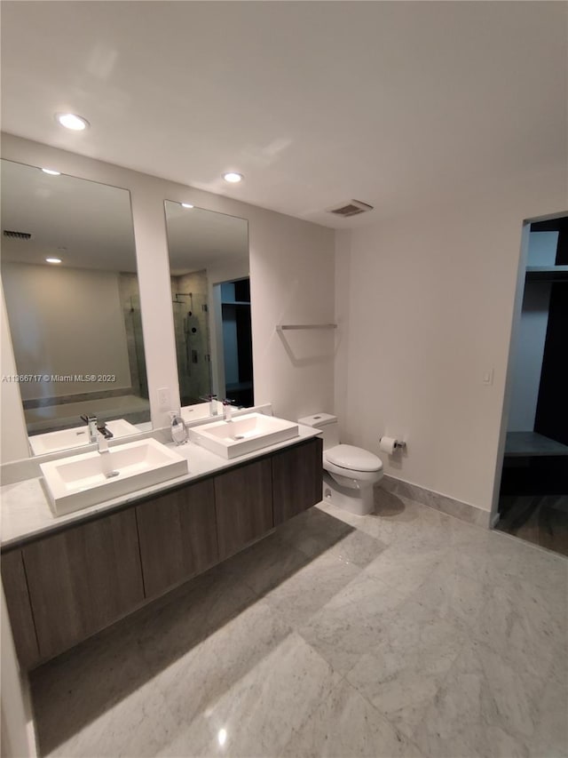 bathroom with toilet, a shower with door, and vanity