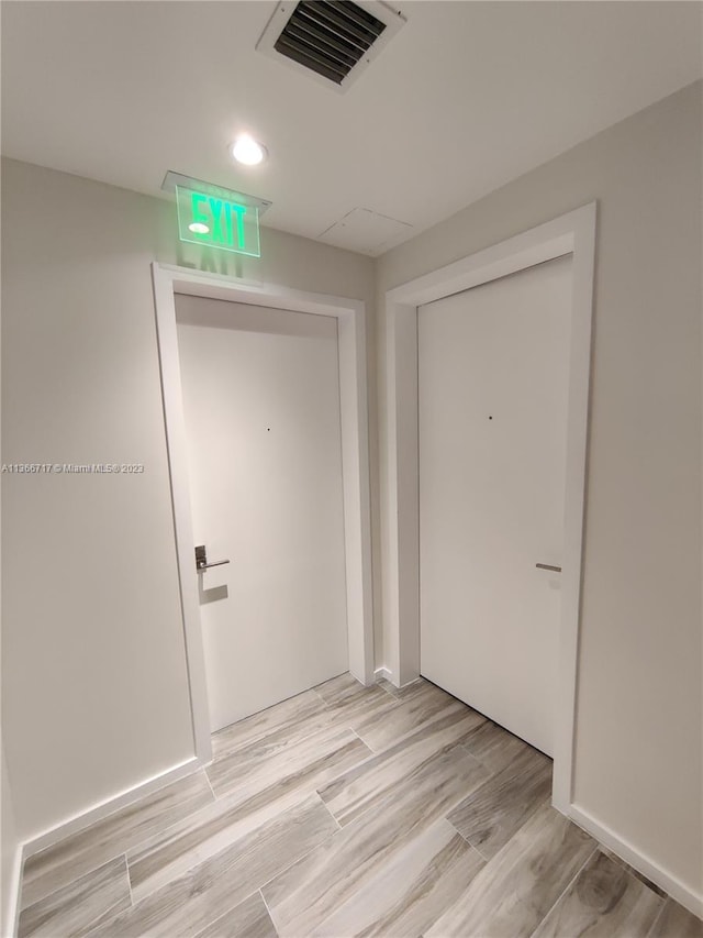 corridor with light hardwood / wood-style flooring