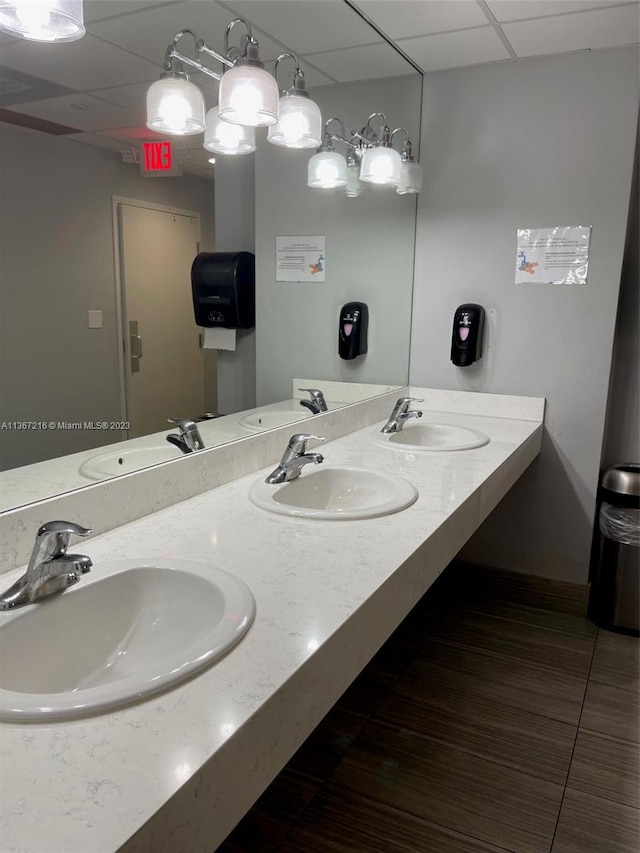 bathroom featuring a paneled ceiling and vanity